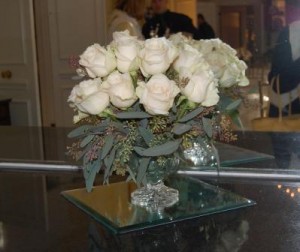 table arrangement of white roses and seeded eucalyptus
