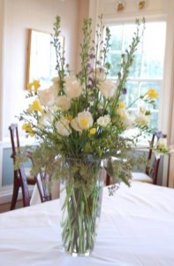 large table arrangement featuring larkspur, stock, freesia, hydrangea, and roses