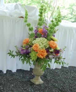 large arrangement of roses, hydrangea, and bells of ireland