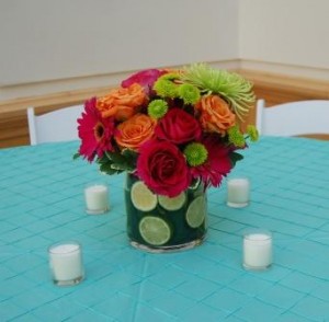 bright arrangement of flowers, accented with sliced limes in the vase