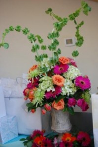 large table arrangement of colorful gerberas, hydrangea, spider mums, and bells of ireland